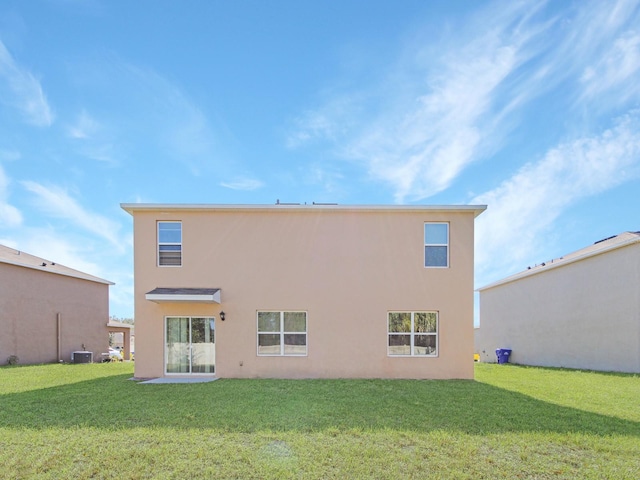 rear view of property with central AC and a lawn