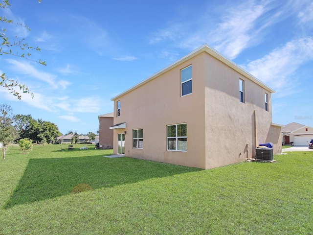 back of property with a yard and central air condition unit