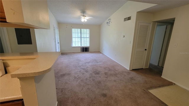 unfurnished living room with a textured ceiling, light carpet, ceiling fan, and vaulted ceiling