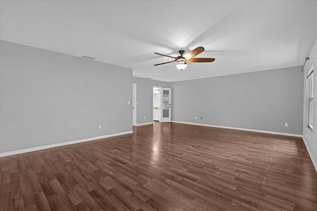 unfurnished living room featuring ceiling fan and dark wood-type flooring