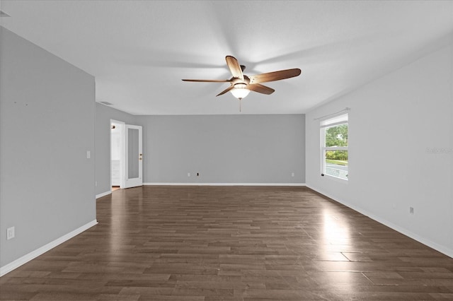 empty room with ceiling fan and dark hardwood / wood-style flooring