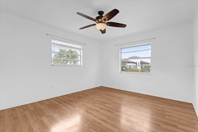 spare room with ceiling fan, a healthy amount of sunlight, and light hardwood / wood-style flooring