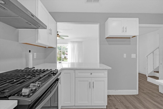 kitchen featuring white cabinetry, light hardwood / wood-style flooring, stainless steel range oven, and ventilation hood