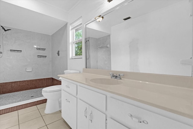 bathroom featuring vanity, crown molding, tiled shower, tile patterned flooring, and toilet