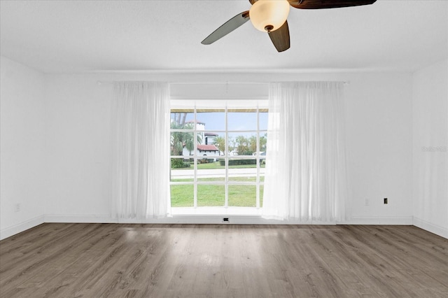 empty room with hardwood / wood-style floors and ceiling fan