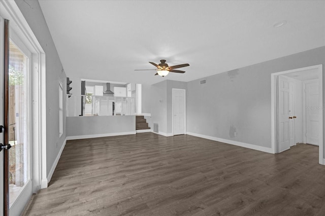 unfurnished living room featuring ceiling fan and dark hardwood / wood-style floors