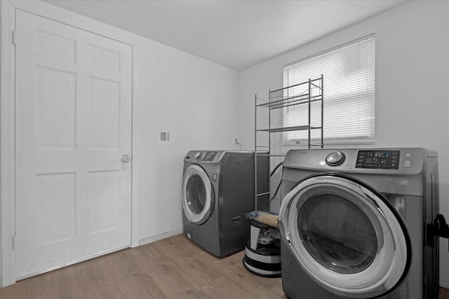 laundry area featuring separate washer and dryer and light wood-type flooring