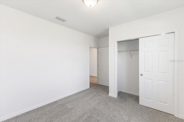 unfurnished bedroom with light carpet and a closet