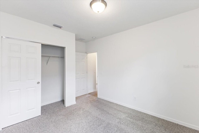 unfurnished bedroom with a closet and light colored carpet