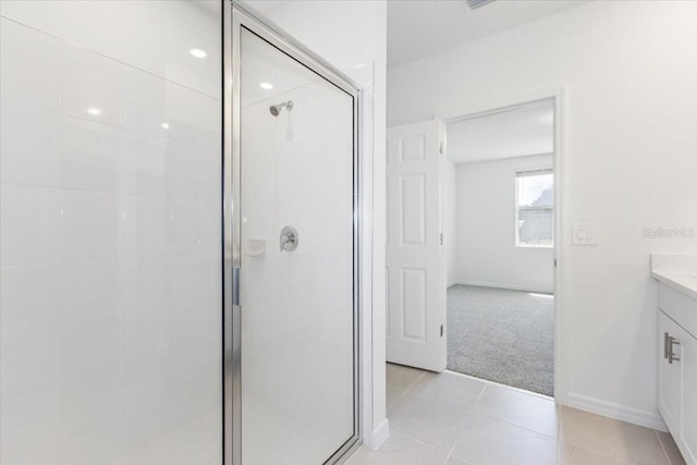 bathroom featuring tile patterned flooring, vanity, and a shower with shower door