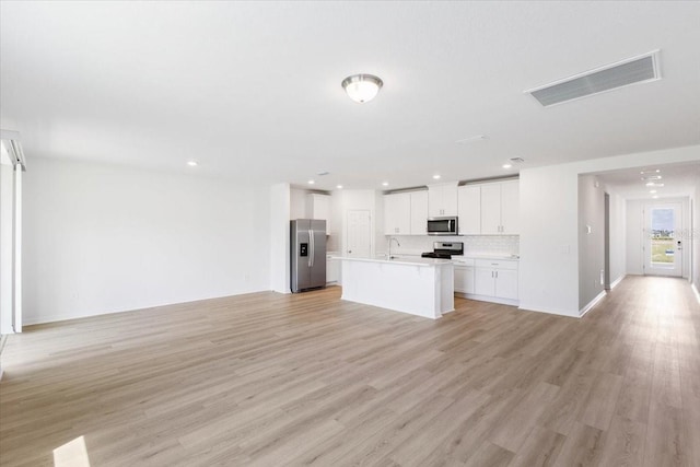 kitchen with sink, stainless steel appliances, light hardwood / wood-style floors, a center island with sink, and white cabinets