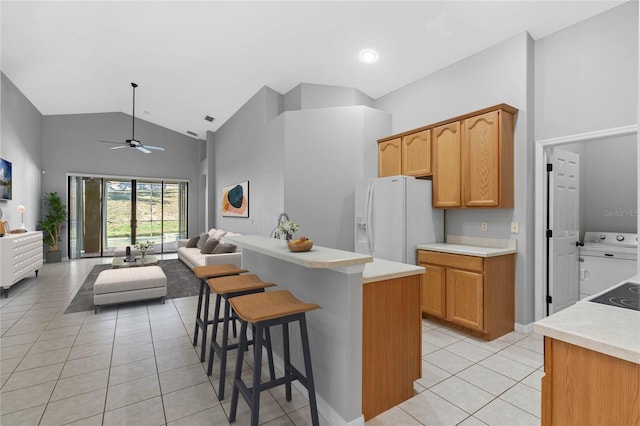 kitchen featuring ceiling fan, a center island, white fridge with ice dispenser, high vaulted ceiling, and light tile patterned floors