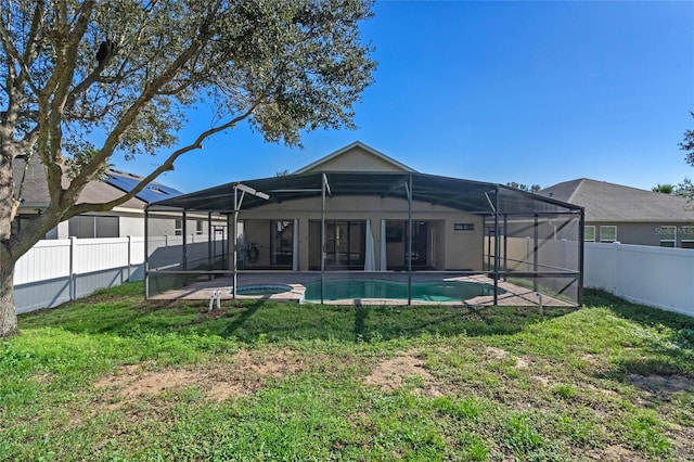 rear view of property featuring a lanai and a lawn