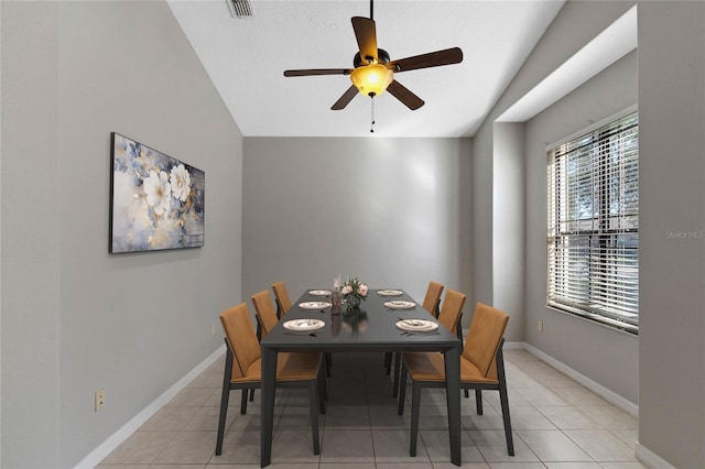 tiled dining room with ceiling fan and lofted ceiling