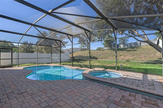 view of pool with a patio area, a lanai, and an in ground hot tub