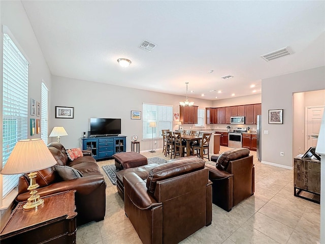 living room with light tile patterned floors and a notable chandelier