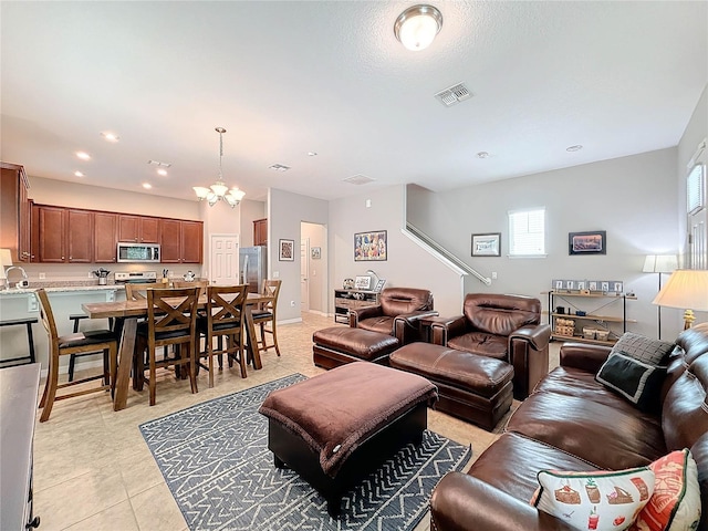 living room featuring light tile patterned floors, an inviting chandelier, and plenty of natural light