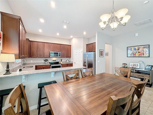 dining space with light tile patterned floors, a notable chandelier, and sink