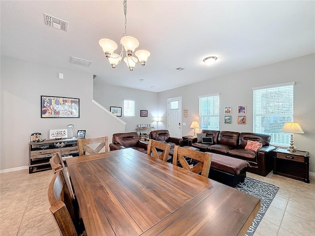 dining space featuring light tile patterned floors and an inviting chandelier