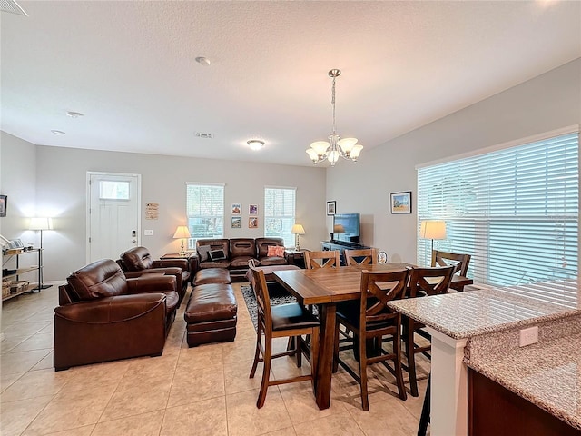 tiled dining area featuring an inviting chandelier