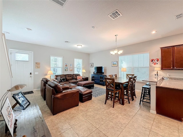 living room with a chandelier, light tile patterned floors, and a healthy amount of sunlight