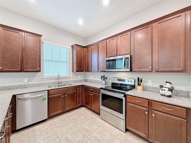 kitchen featuring light stone counters, light tile patterned floors, sink, and appliances with stainless steel finishes