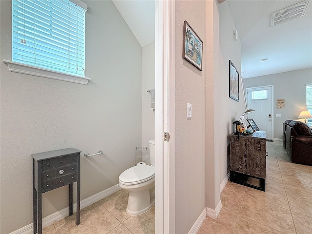 bathroom featuring tile patterned flooring, toilet, and lofted ceiling