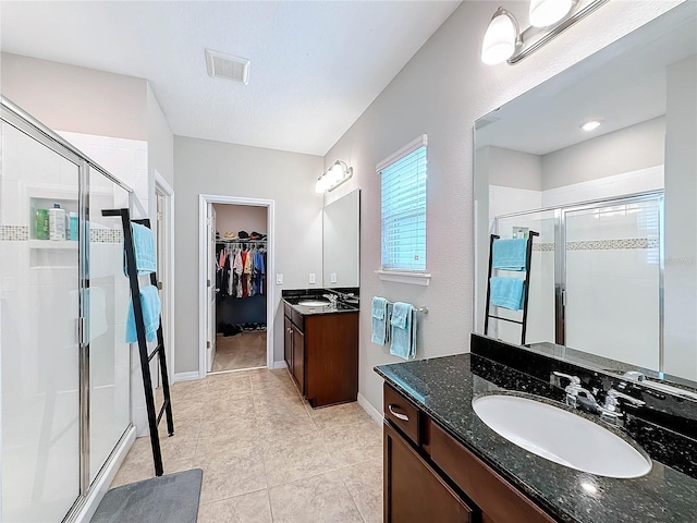 bathroom with tile patterned floors, vanity, and a shower with shower door