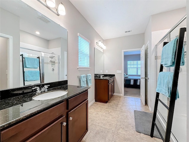 bathroom with tile patterned flooring, vanity, and an enclosed shower