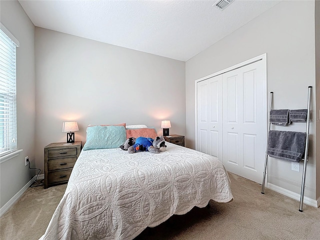 bedroom featuring a closet and light colored carpet