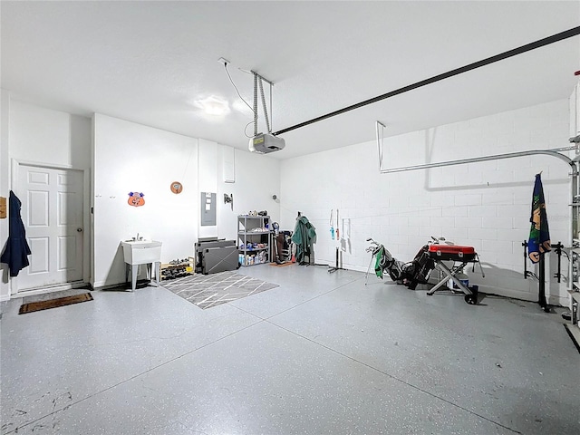 garage featuring electric panel, a garage door opener, and sink