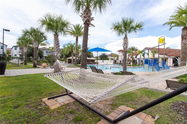 view of home's community featuring a patio area, a yard, and a pool