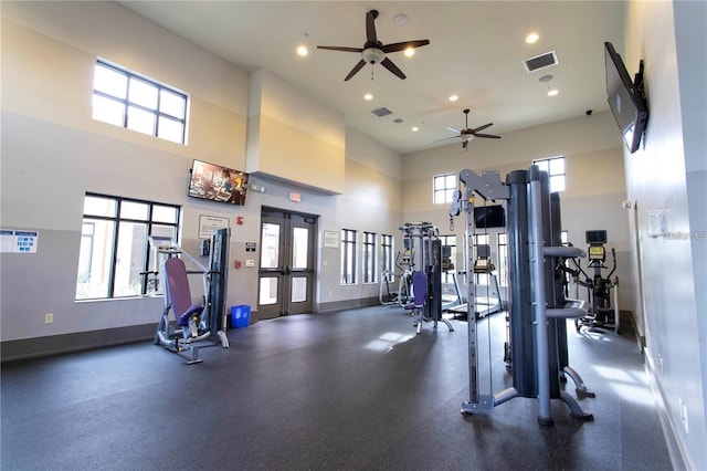 exercise room featuring ceiling fan, a high ceiling, and french doors