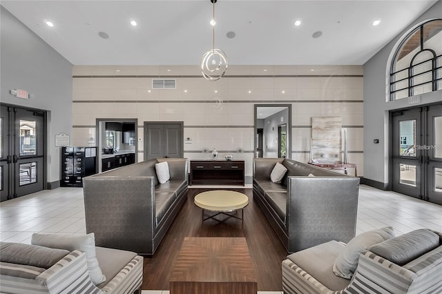 living room featuring tile patterned floors, a towering ceiling, and a wealth of natural light