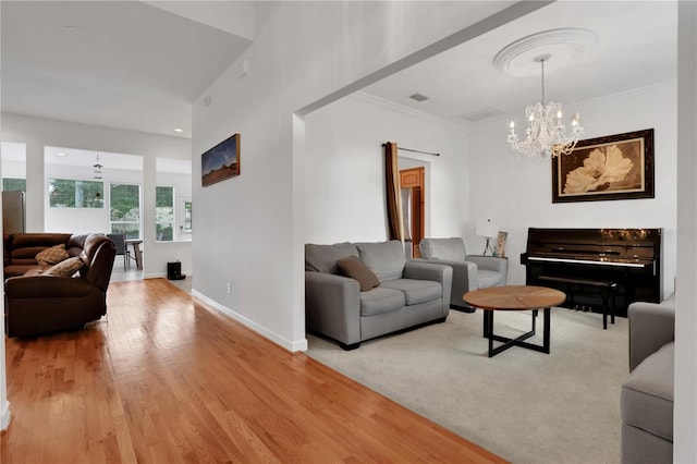 living room with wood-type flooring, crown molding, and a notable chandelier