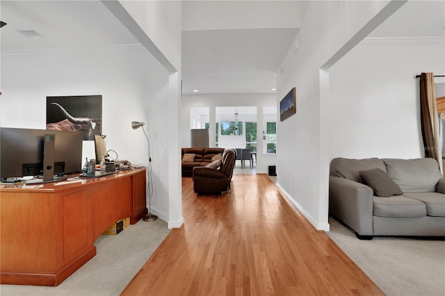 office with light hardwood / wood-style floors, ceiling fan, and ornamental molding