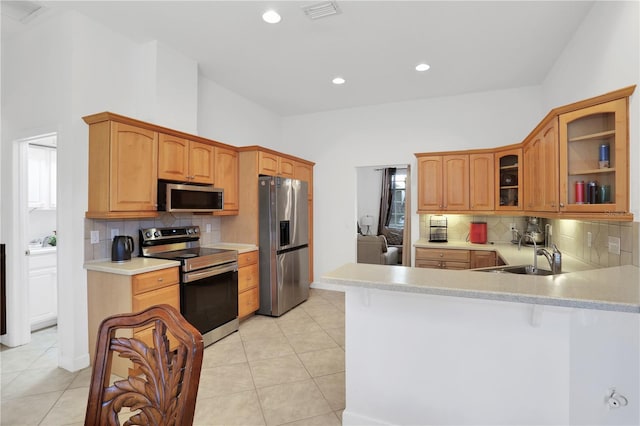 kitchen featuring light tile patterned flooring, sink, kitchen peninsula, and stainless steel appliances