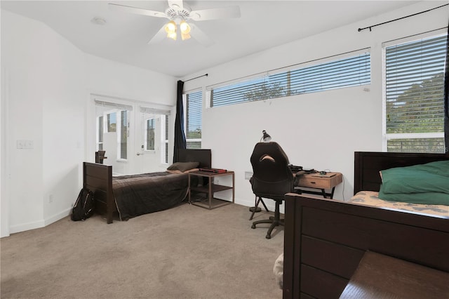 bedroom featuring ceiling fan, light colored carpet, and multiple windows