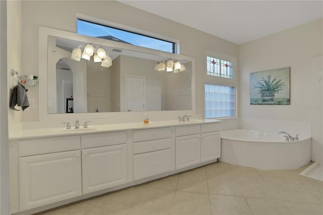 bathroom with tile patterned floors, a tub, and vanity