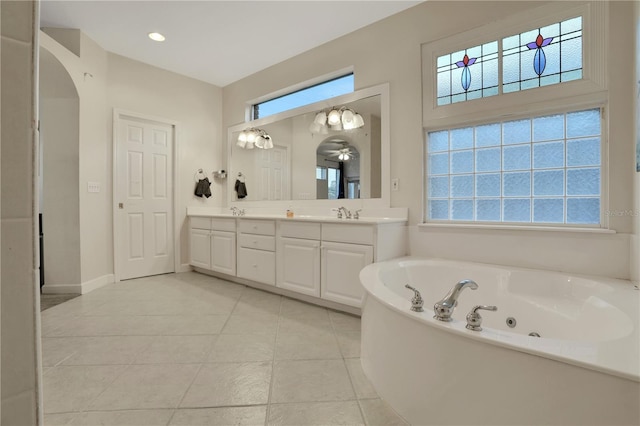 bathroom with tile patterned flooring, vanity, and a tub