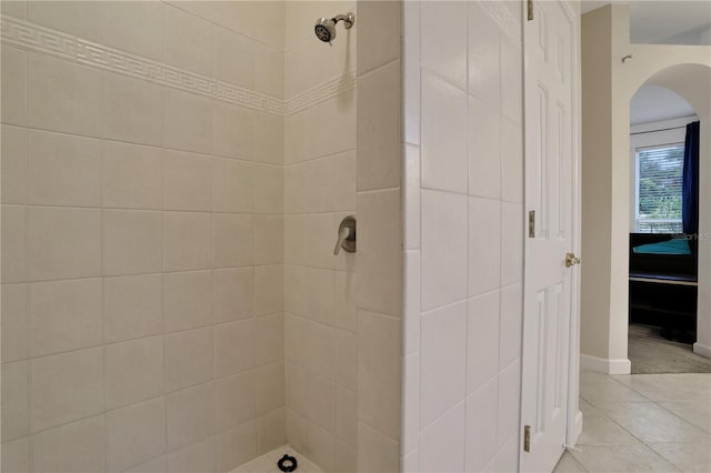 bathroom featuring tile patterned flooring and a tile shower