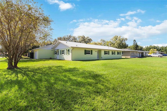 rear view of property featuring a lawn