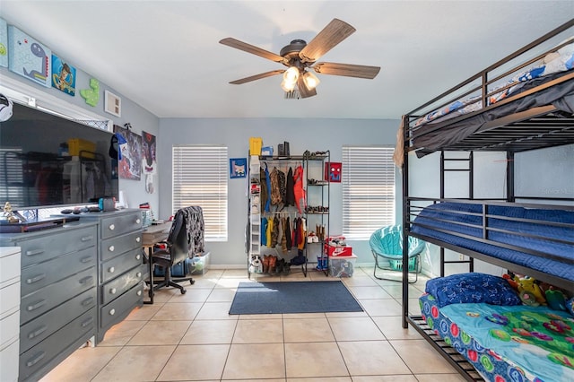 bedroom featuring ceiling fan, light tile patterned flooring, and multiple windows