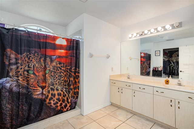 bathroom featuring tile patterned flooring, vanity, and walk in shower