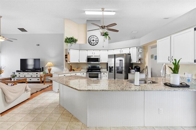 12512 Tillingham Ct SW, Orlando, FL 32837 - kitchen with appliances with stainless steel finishes, a ceiling fan, a sink, a peninsula, and high vaulted ceiling
