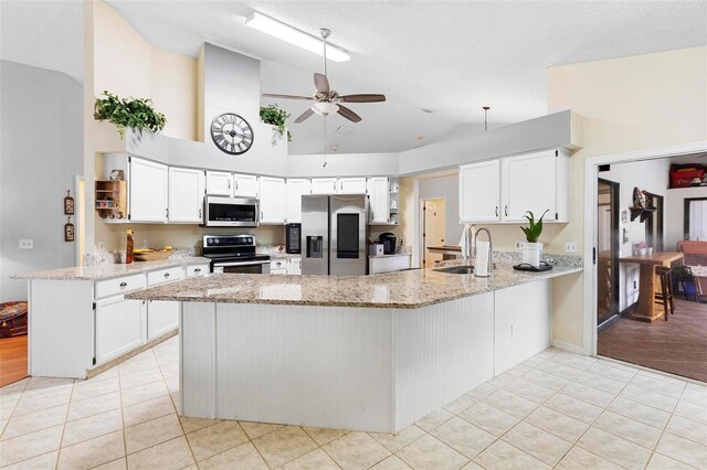 12512 Tillingham Ct SW, Orlando, FL 32837 - kitchen featuring appliances with stainless steel finishes, a sink, a peninsula, ceiling fan, and high vaulted ceiling