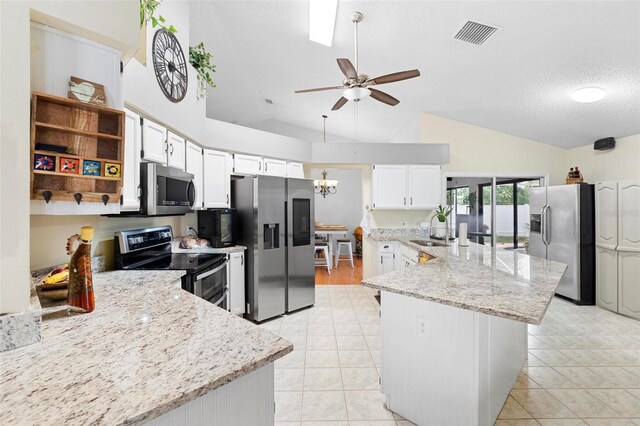 12512 Tillingham Ct SW, Orlando, FL 32837 - kitchen with stainless steel appliances, lofted ceiling, a sink, light stone countertops, and light tile patterned floors
