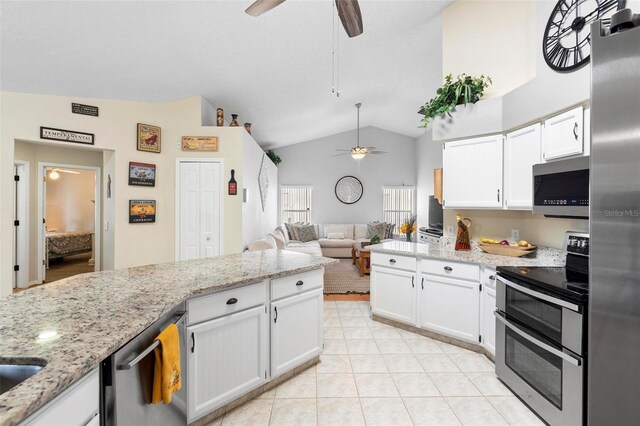 12512 Tillingham Ct SW, Orlando, FL 32837 - kitchen with appliances with stainless steel finishes, ceiling fan, white cabinets, light tile patterned flooring, and light stone counters