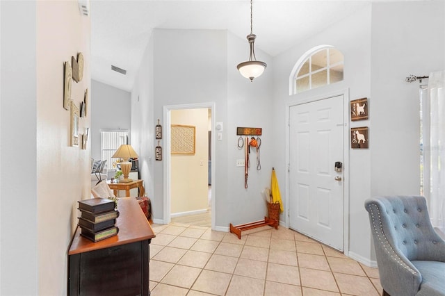 tiled entryway featuring high vaulted ceiling