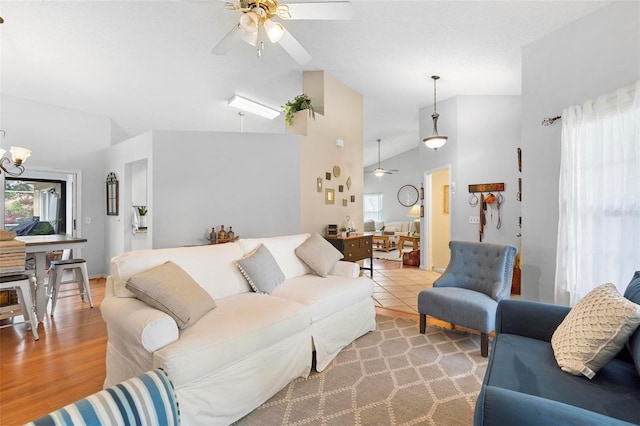 living room with ceiling fan, light wood-type flooring, and lofted ceiling